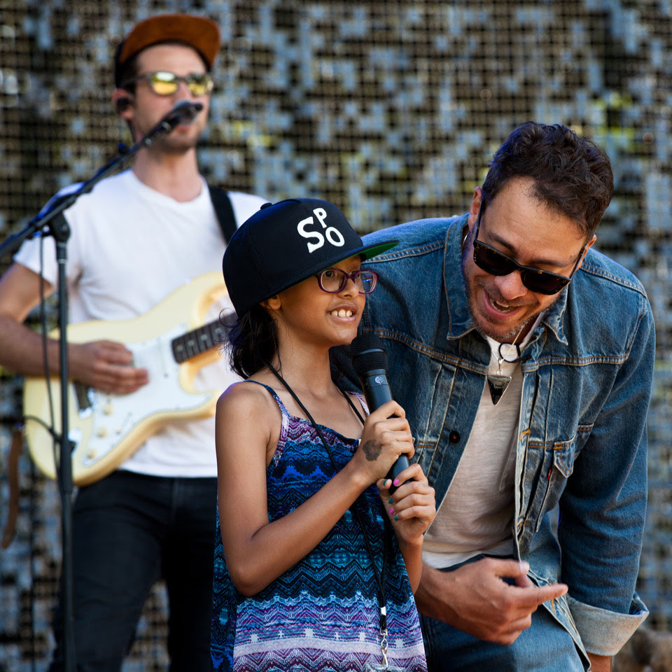 Amos Lee (right) is joined on stage by Melodic Caring Project rockSTAR Maya at a concert at Seattle's Woodland Park Zoo in 2019